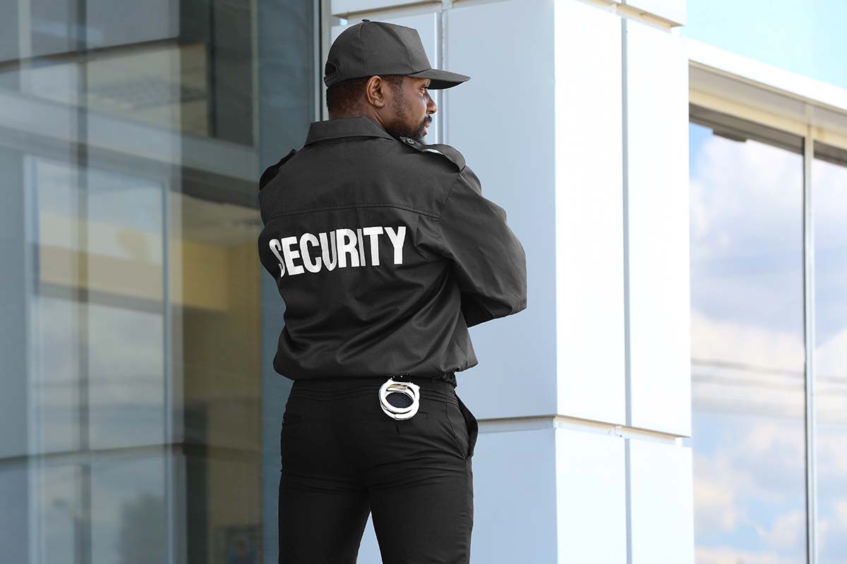 Male security guard standing near big modern building