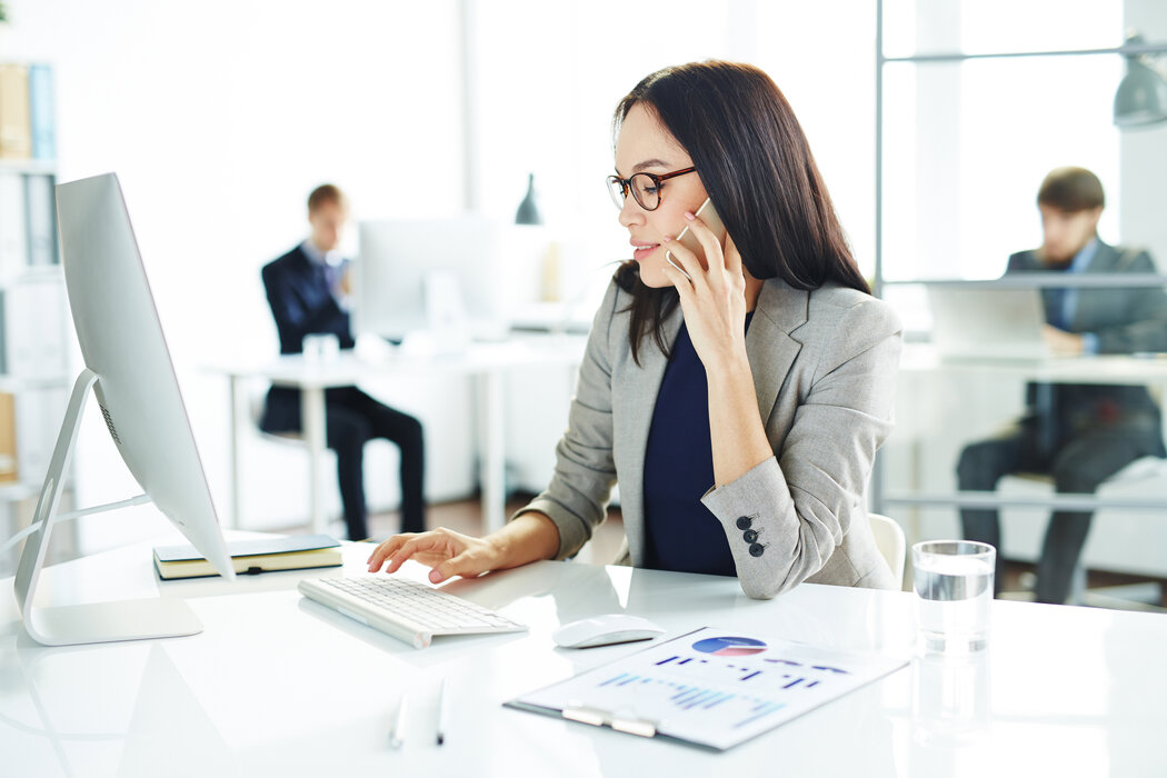 Businesswoman speaking on the phone and browsing online